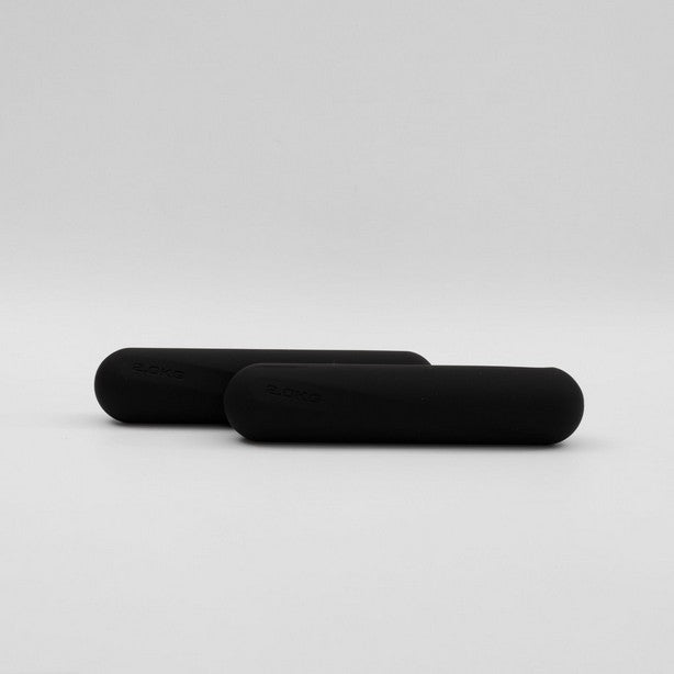 A pair of black dumbbell strength bars laid on a white surface.