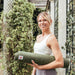 Jute Yoga Mat Sustainable Non-Slip Yoga Mat CompleteGrip™ Jute 4mm - Lady in London park holding a jute yoga mat #colour_space-black